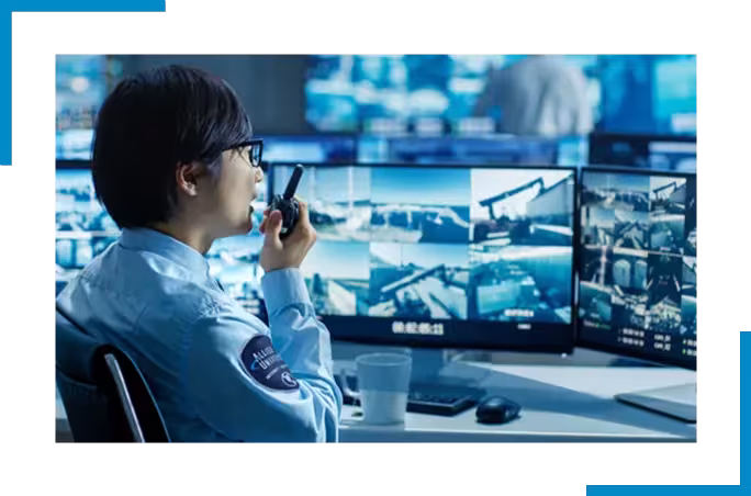 Security guard at monitors using walkie talkie.